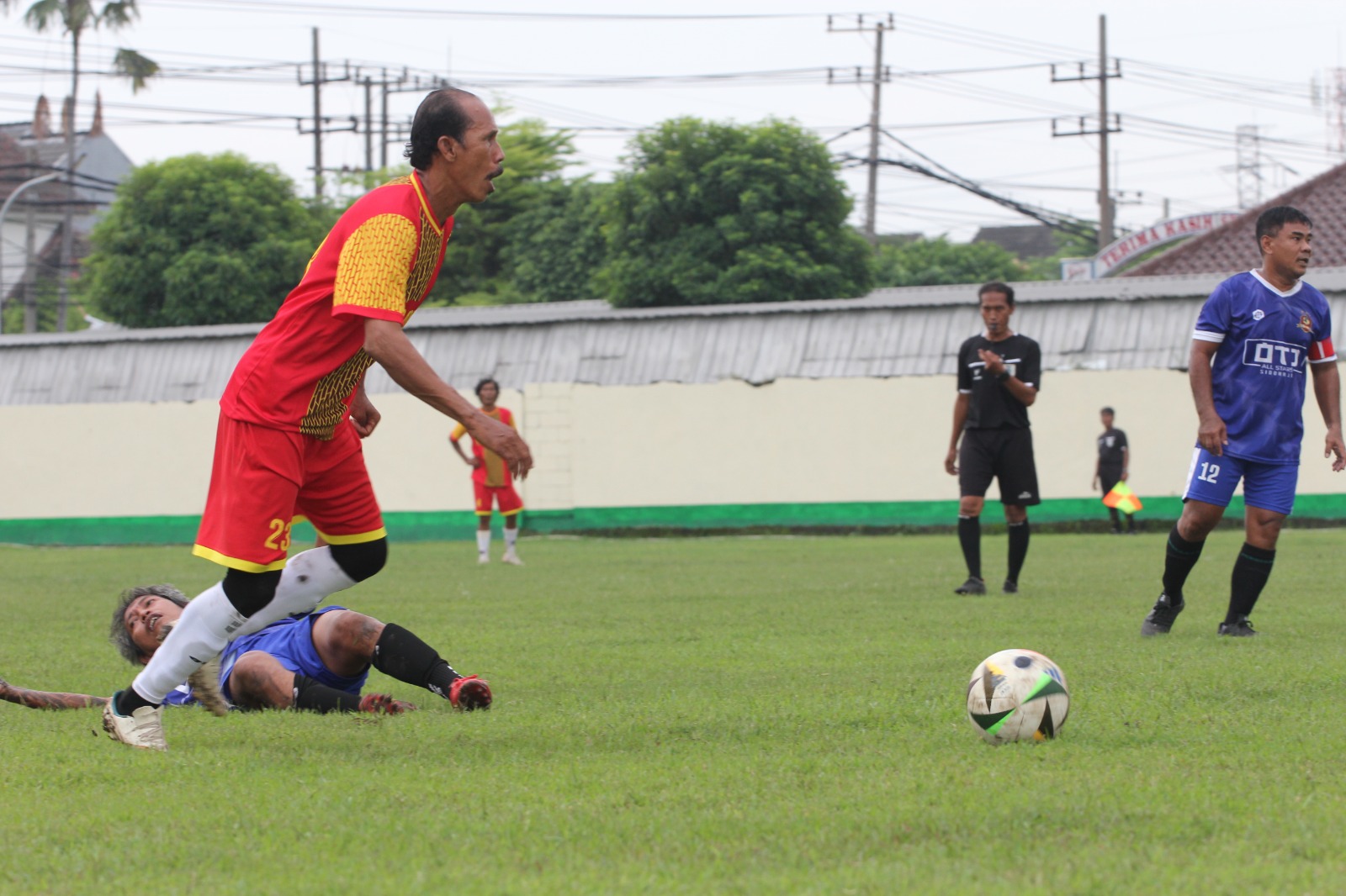Winger Buduran FC Ahmad Khozin lepas dari tekling pemain OTJ dalam pertandingan Pesawad Cup U50 2025 di Lapangan Wedowo, Waru