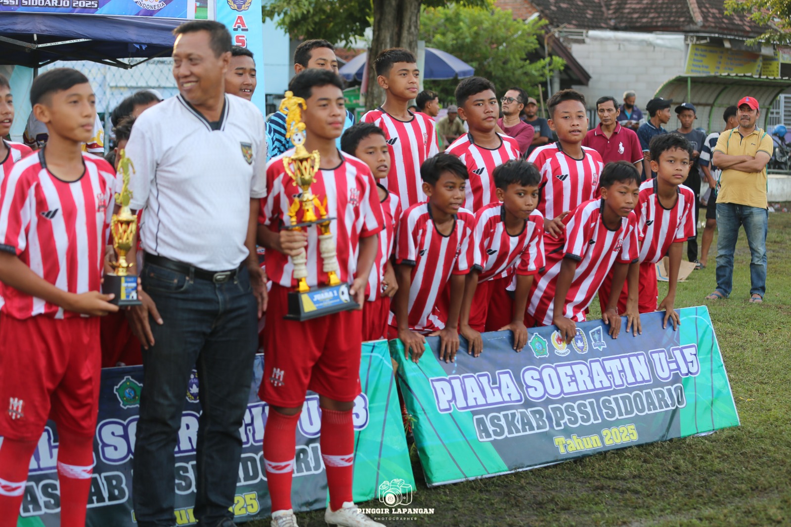 Ketua Askab PSSI Sidoarjo terpilih Puji Daryo (dua dari kiri) saat penyerahan piala ke Deltras U-13 di Lapangan Pagerwojo Senin (9/6/2025)