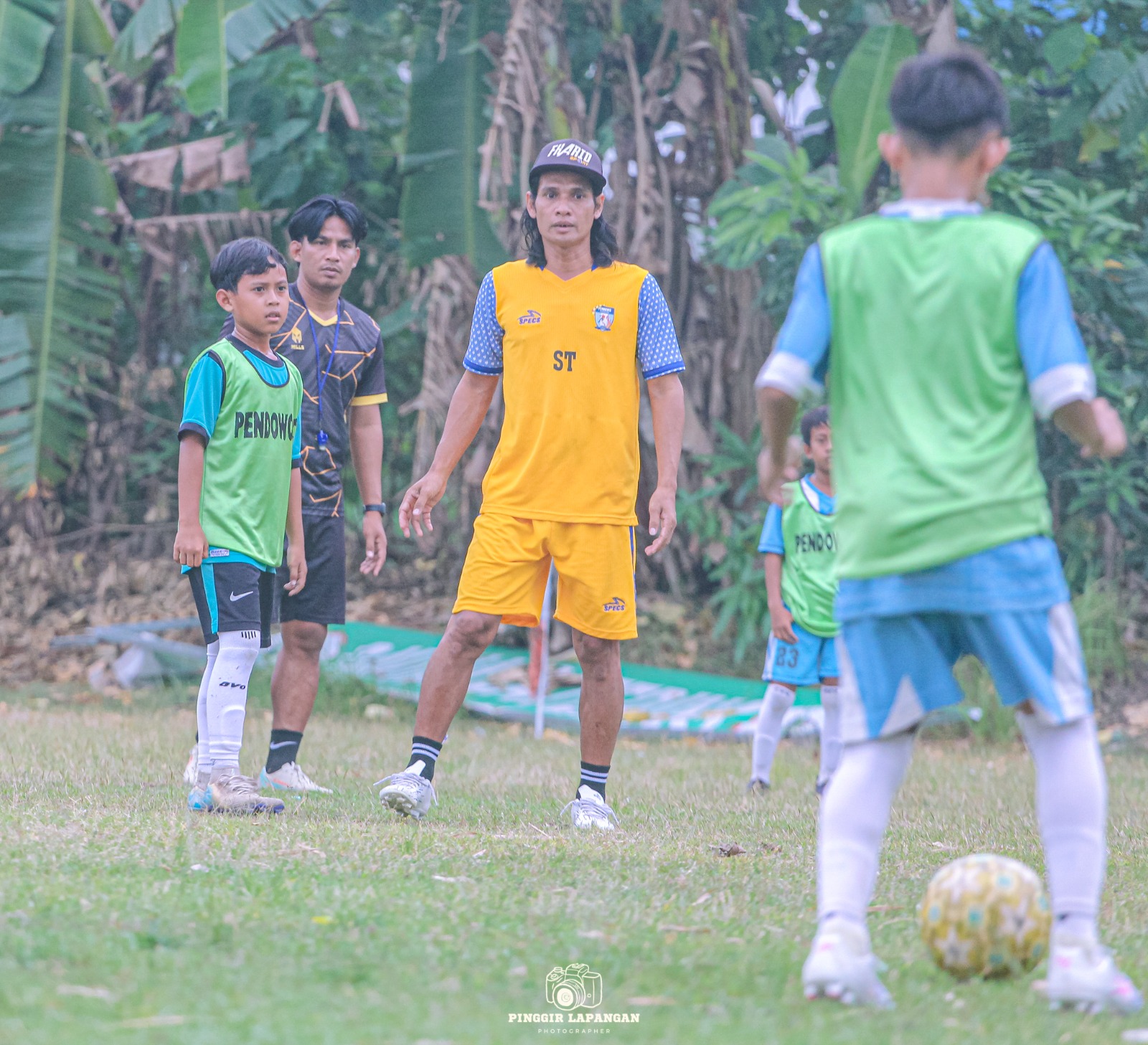 Sutriono (kanan) dan adiknya, Wahyu (tengah) saat memantau para pemain Pendowo FC Sukodono berlatih pada Rabu sore (22/10/2025).